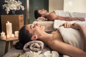 Junger Mann und Frau liegen auf Massagebetten in einem Luxus-Spa und Wellness-Center