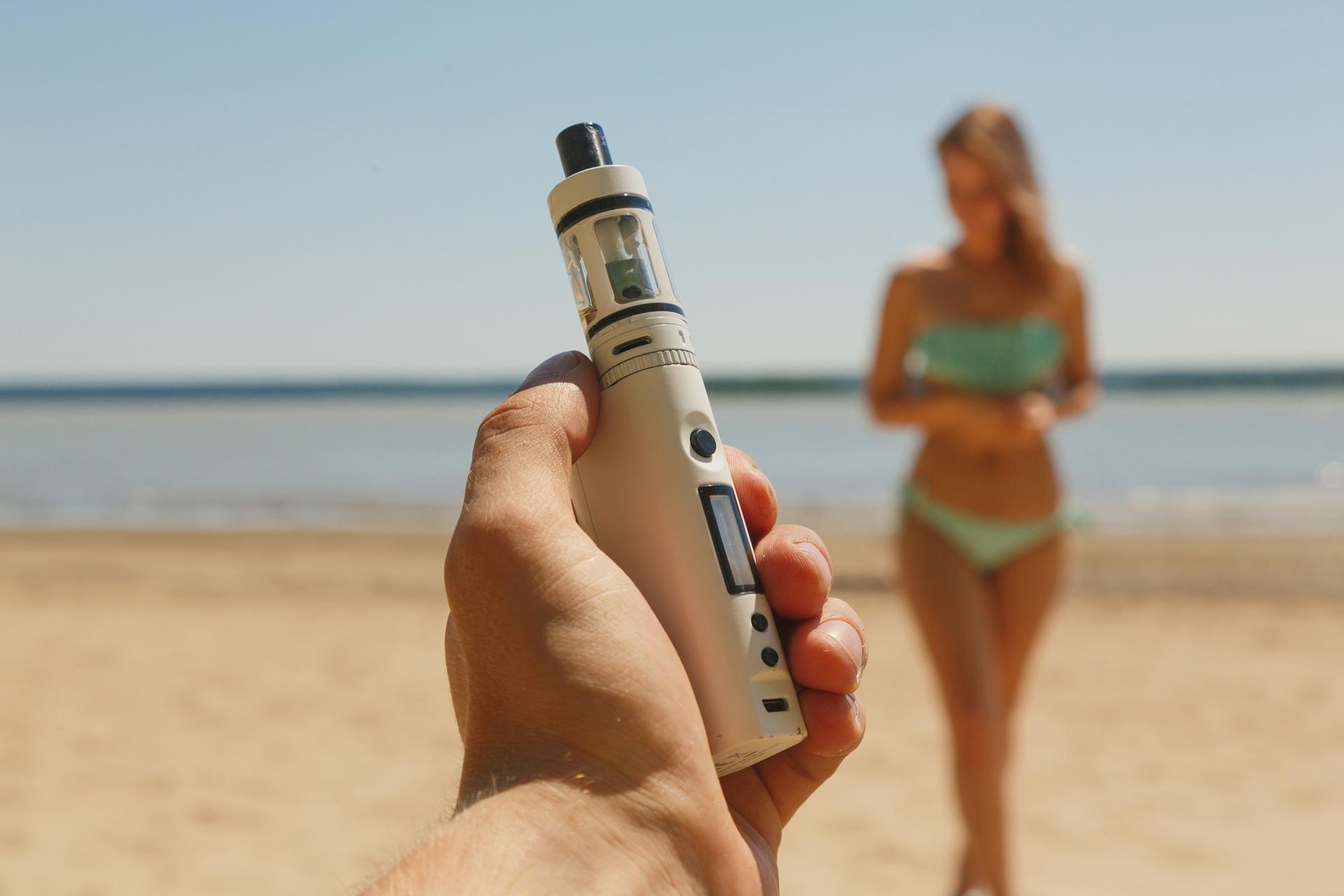 Hand hält E-Zigarette am Strand | Elf Bar Vape

