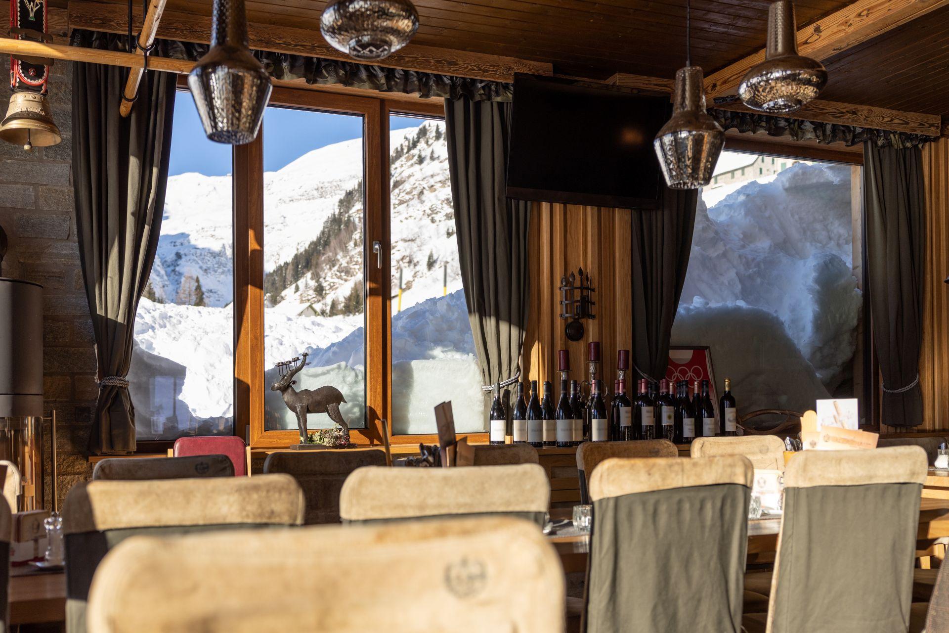 Gemütliches Restaurant mit Holzeinrichtung und Blick auf verschneite Berge, kulinarische Erlebnisse beim Aufenthalt im Hotel Kleinarl